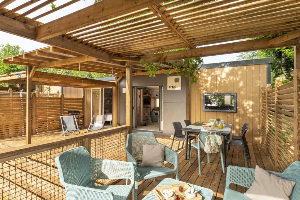 Terrasse en bois aménagée avec fauteuils et table.