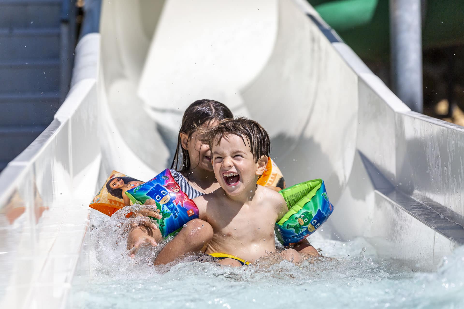 Enfants riant dans un toboggan aquatique.